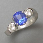 Other Rings 1-6: Oval blue sapphire in prongs with round partial bezel set diamonds in a white gold setting with a twist