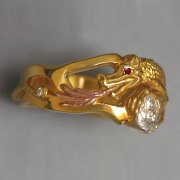 Other Rings 2-12: Round cut diamond set in a platinum moon held by a yellow gold dragon breathing rose gold fire with a ruby eye