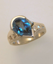 Other Rings 2-8: Pear shaped blue topaz off set in a partial bezel with diamonds in white gold
