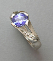 Other Rings 3-11: Oval blue sapphire in a stylized prong setting with channel set diamonds in white gold