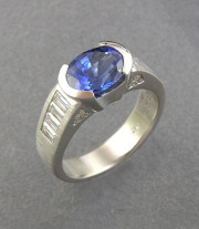Other Rings 3-2: Oval blue sapphire partial bezel set with diamond baguettes on the sides in platinum
