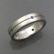 Bands 1-11: Small round blue sapphires set around a grooved line in white gold