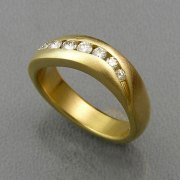 Bands 2-12: Curved band with small full cut diamonds channel set in yellow gold