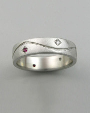 Bands 2-2: Small diamonds and rubies bead set around a curved line in platinum