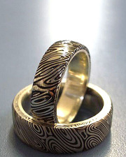 Oxidized Damascus Stainless Steel wedding set lined in 18k Yellow gold