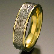 Damascus stainless steel Infinity pattern set in 18kt. Yellow Gold narrow rails, flat band style