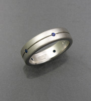 14k White gold Textured band with recessed line, flush set with small Round Blue Sapphires