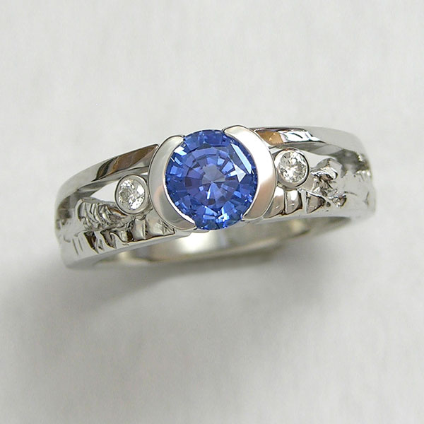Mountain Engagement Rings 1-9: Platinum mountain ring with sapphire in partial bezel and a bezel set diamond on each side
