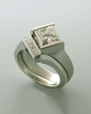1-1: Princess cut diamond engagement ring set in partial bezel with a twist