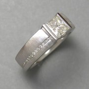 Engagement Ring 1-2: Princess cut diamond channel set in white gold with small channel set side diamonds