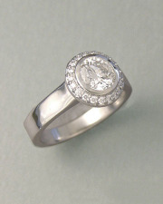 Engagement Ring 1-3: Round cut diamond full bezel set in platinum surrounded by small bead set diamonds