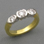 Engagement Ring 1-4: Three round cut diamonds in partial bezel setting in platinum and 18k yellow gold