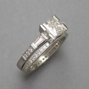 Engagement Ring 1-8: Princess cut diamond in a platinum prong setting with tapered baguettes