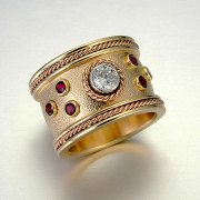 Engagement Ring 2-1: Round cut diamond in platinum full bezel set in yellow gold with full bezel set garnets
