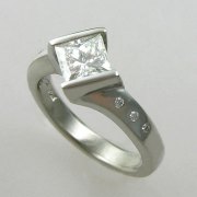 Engagement Ring 2-3: Princess cut diamond channel set in white gold with flush set diamonds down the sides
