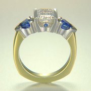 Engagement Ring 3-1: Emerald cut diamond channel set in platinum and 18k yellow gold with blue triangular sapphires on the sides