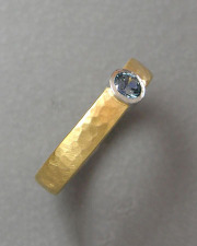 Engagement Ring 3-10: Round cut blue sapphire full bezel set in platinum and 18k yellow gold with a hammered texture