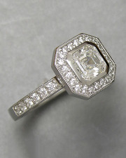 Engagement Ring 3-12: Modified emerald cut diamond full bezel set in platinum with bead set diamonds and mill grain detail