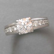 Engagement Ring 4-11: Round cut diamond square prong set in platinum with bead set diamonds on the sides