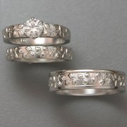 Engagement Ring 4-5: Round cut diamond prong set in white gold with vine details on the sides shown with matching bands