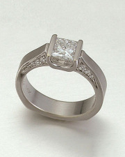 Engagement Ring 4-7: Princess cut diamond channel set in white gold with bead set diamonds in the sides