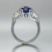 Engagement Ring 5-1: Cushion cut blue sapphire prong set in platinum with triangular diamonds on the sides