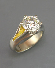 Engagement Ring 5-3: Round cut diamond prong set in platinum with 24karat yellow gold on the sides