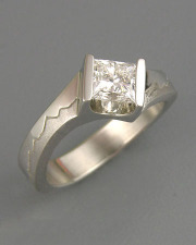 Engagement Ring 5-8: Princess cut diamond channel set in white gold with mountains on the sides