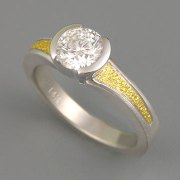 Engagement Ring 6-3: Round cut diamond partial bezel set with 24karat gold on the sides