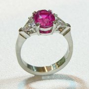 Engagement Ring 6-6: Oval cut pink sapphire prong set in platinum with triangular diamonds on the sides