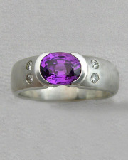 Engagement Ring 7-3: Oval cut purple sapphire partial bezel set in white gold with diamonds on the sides