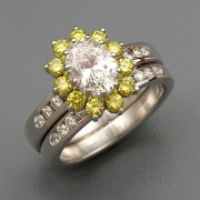 Engagement Ring 7-5: Oval cut diamond prong set in platinum with yellow diamonds shown with matching channel set diamond band