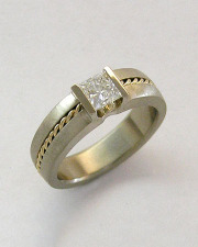 Engagement Ring 8-9: 14kt. white gold engagement ring with princess cut channel set diamond in center and 18kt. yellow gold twisted detail around band