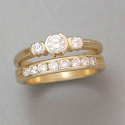 Engagement Ring 9-10: 14kt. yellow gold three stone diamond engagement ring with three partially bezel set round diamonds and a matching diamond channel set wedding band