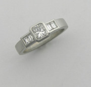 Cushion cut diamond engagement ring with channel set baguette side stones