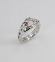 Oval Padparadscha engagement ring with leaves and vine details.